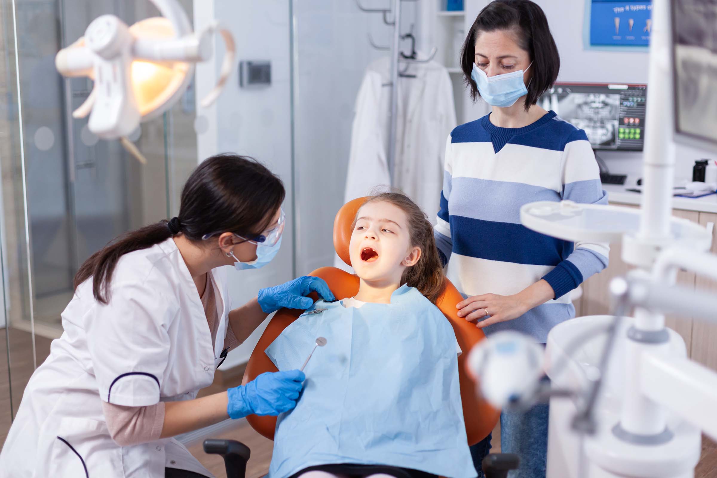 dentist doing teeth check up of little girl NHZG