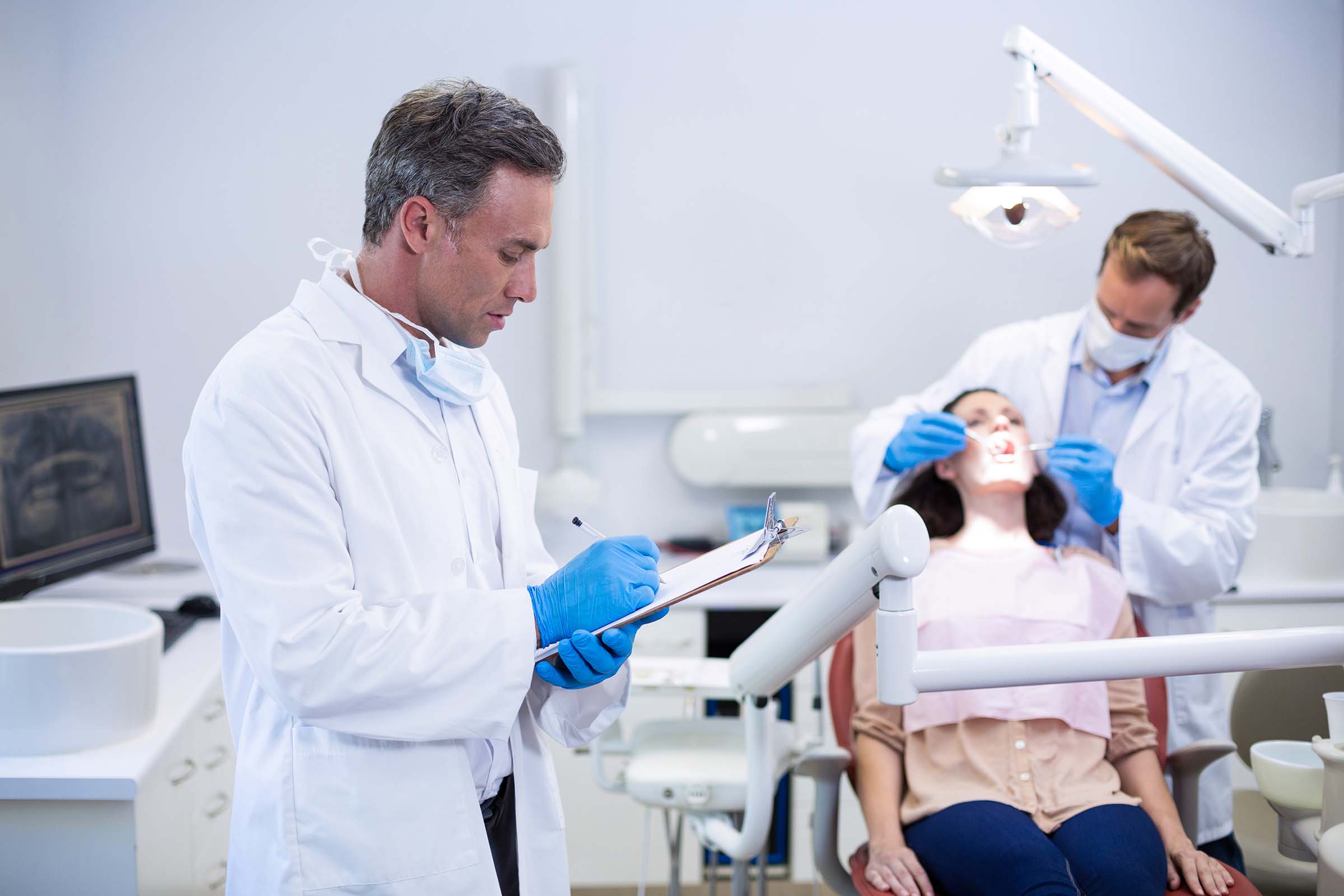dentist writing on clipboard HMZKD